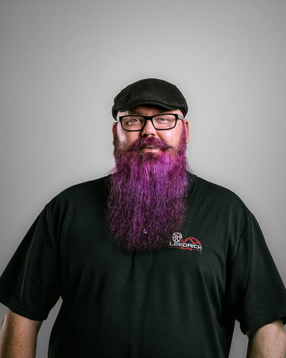A man with purple beard and glasses